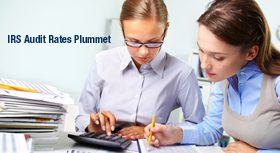 Two womans looking at documents and using a calculator