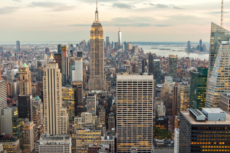 Aerial view of the New York City skyline at dusk, featuring the Empire State Building.