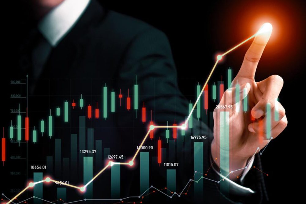 A hand pointing at a glowing, rising stock market line graph with green and red candlestick bars.
